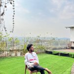 a boy sit on a chair in rooftop cafe ln Hotel Hill Ambassador