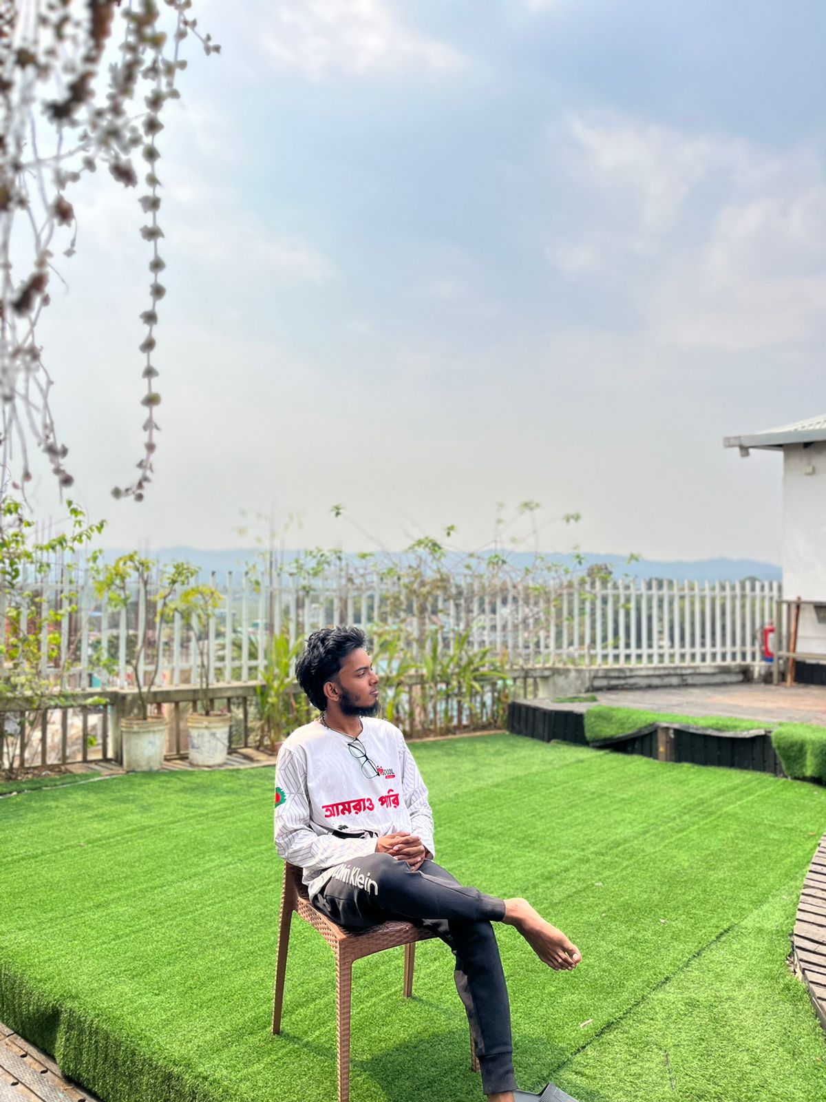 a boy sit on a chair in rooftop cafe ln Hotel Hill Ambassador